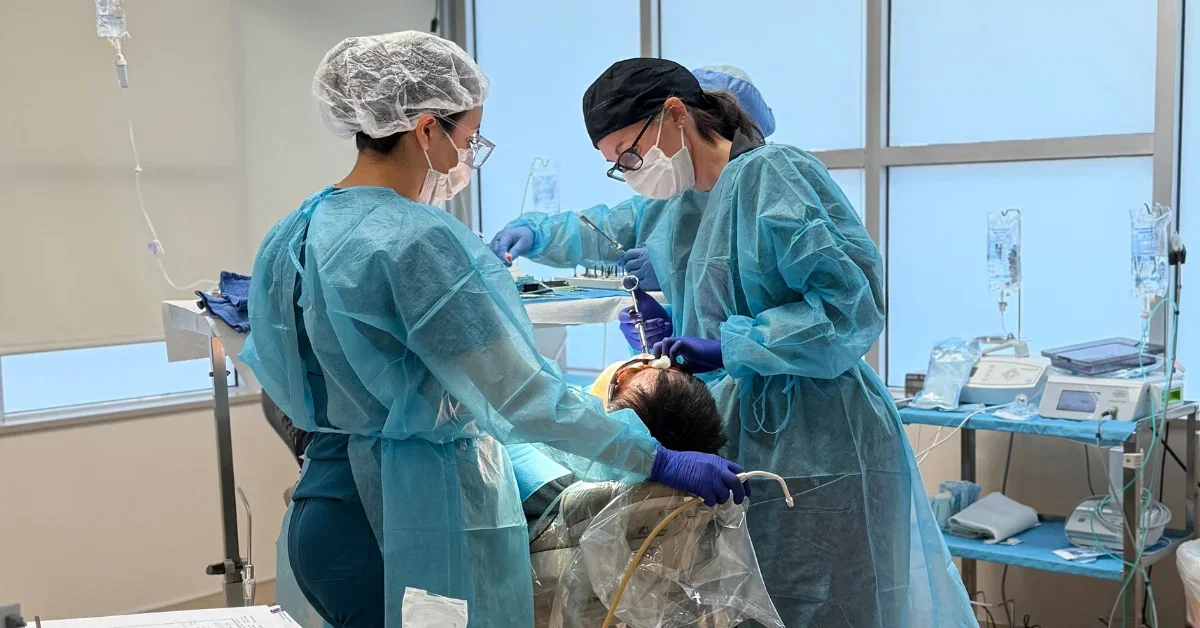 Sedation options for dental implants – clinicians performing implant procedure with patient in chair and monitoring equipment nearby