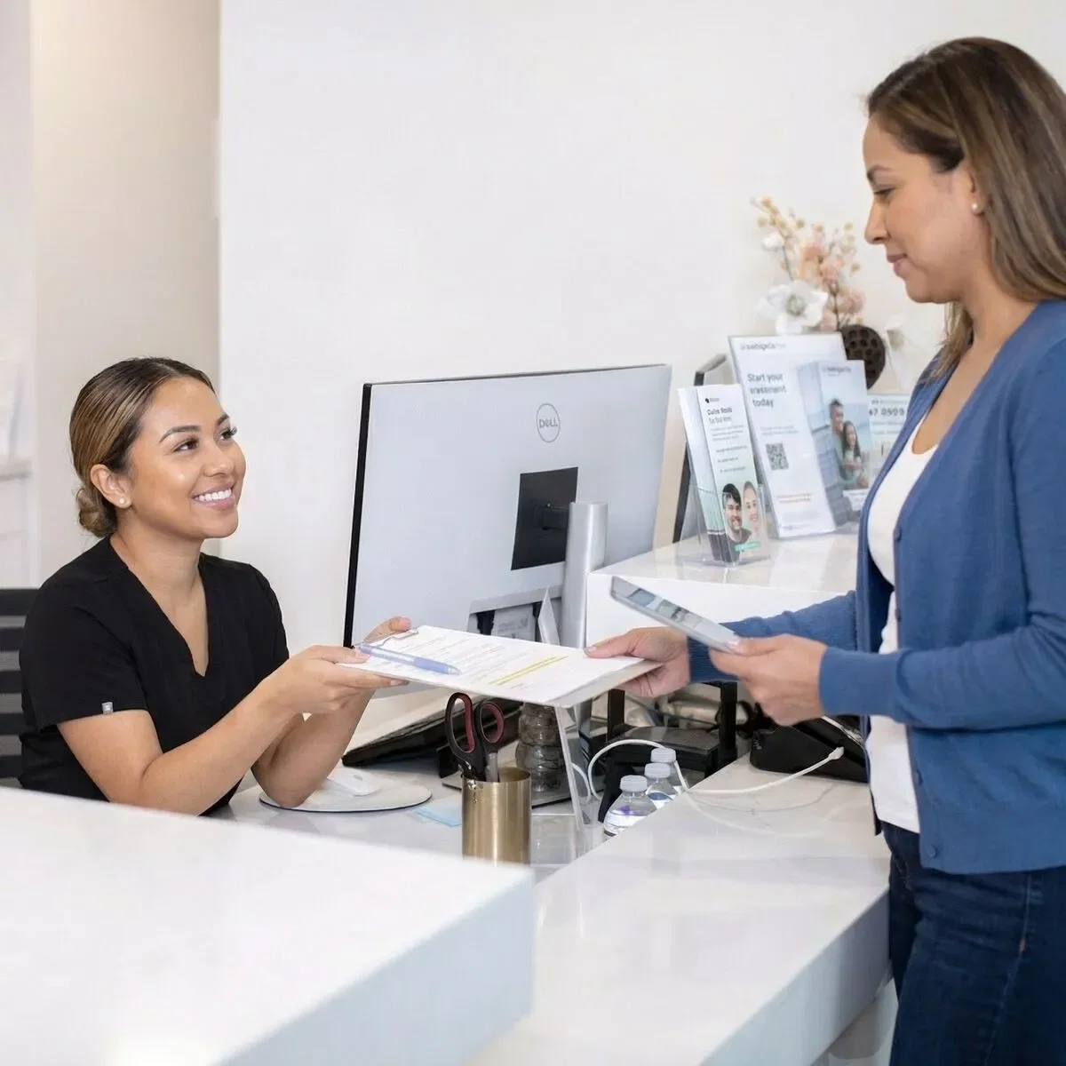 Welcoming front office staff at Fusion Dental Implants greeting a patient
