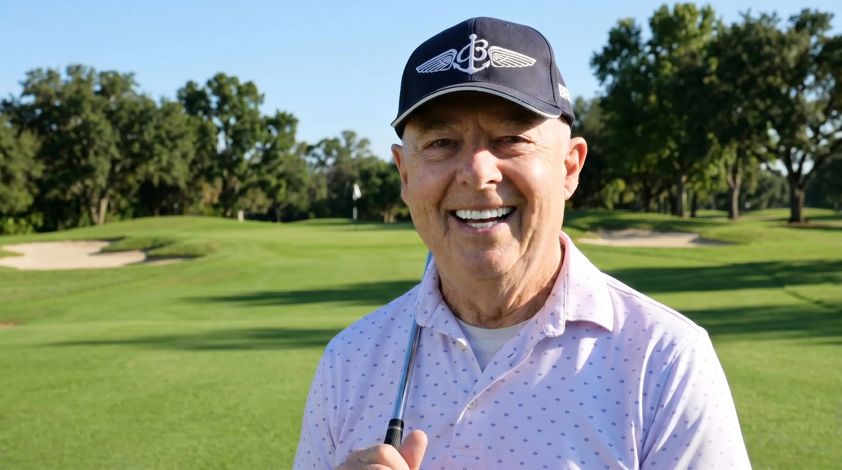 Charles smiling on a golf course after his dental implant treatment