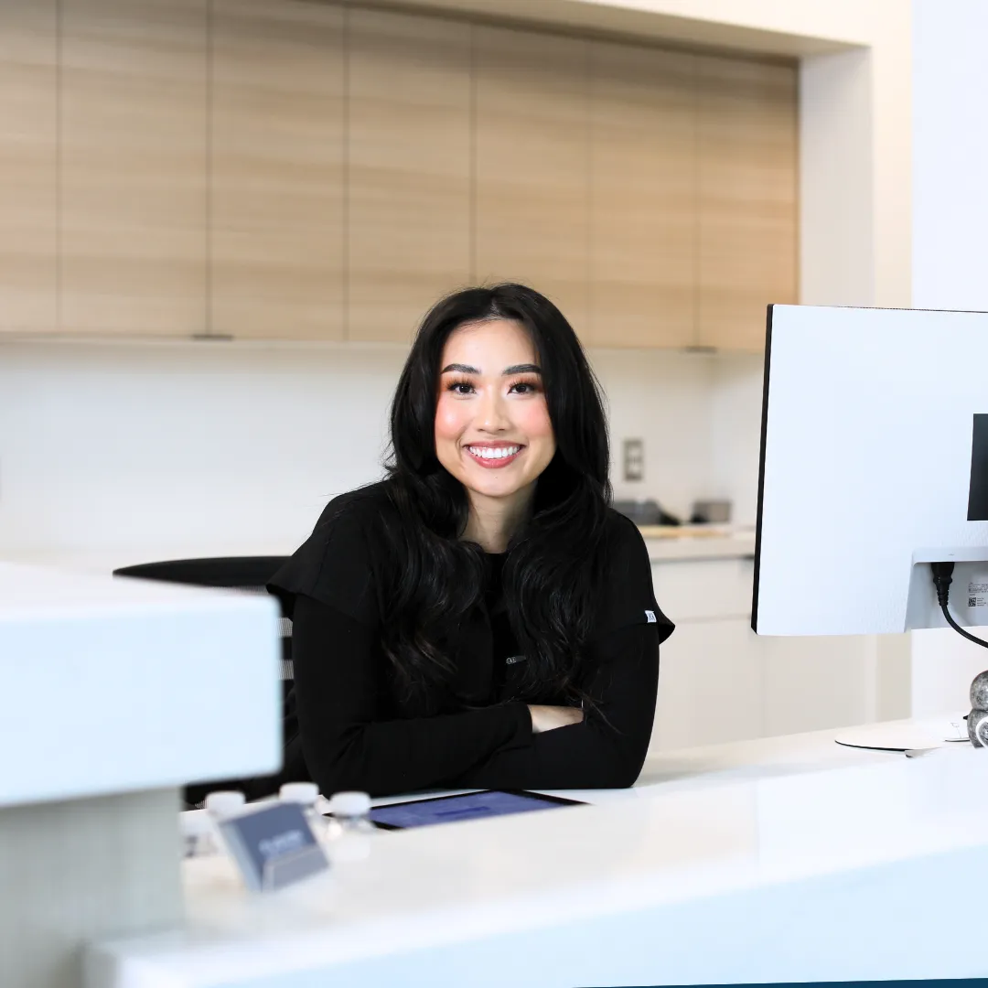 Friendly receptionist welcoming patients at Fusion Dental Implants