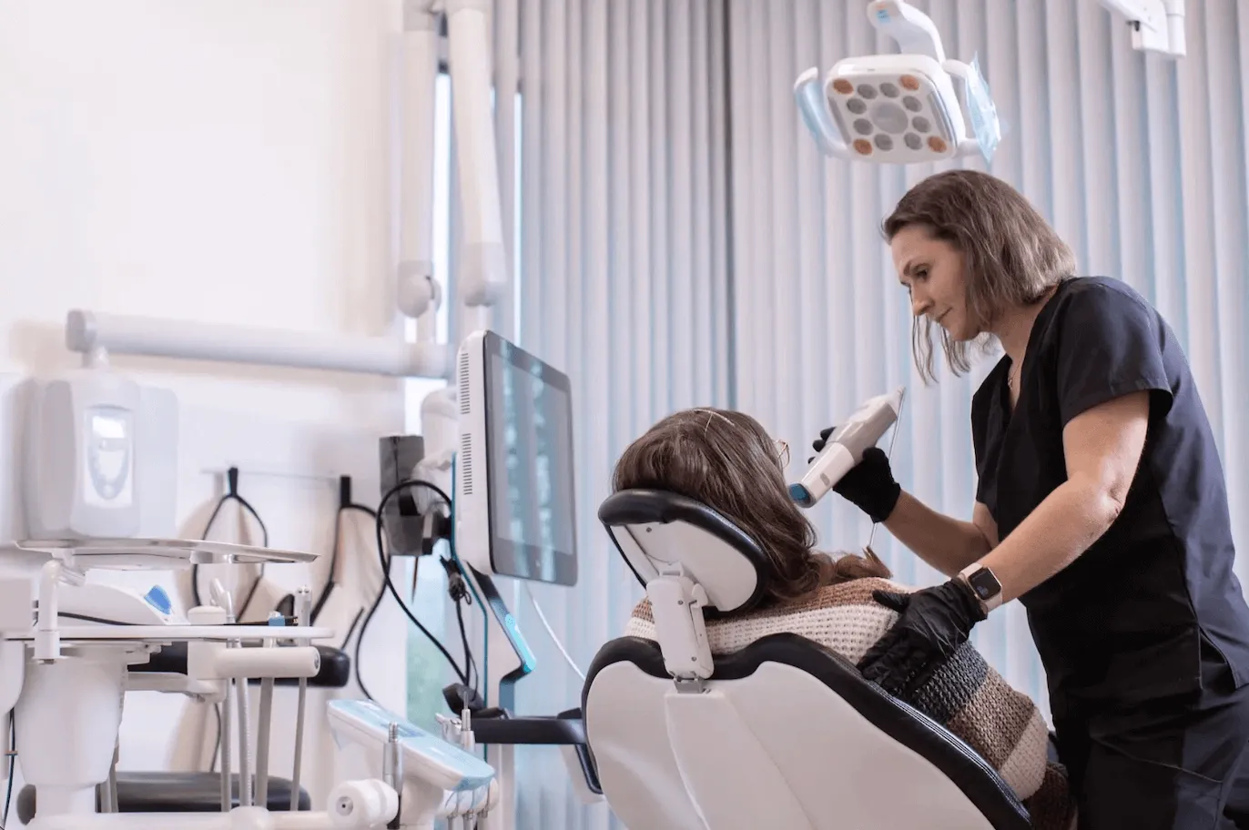 A member of the dental team caring for a seated patient